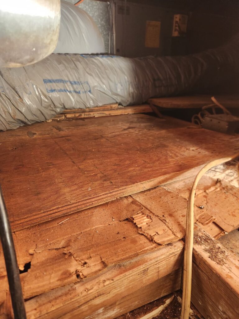 Attic space with old insulation and ducting before cleanup